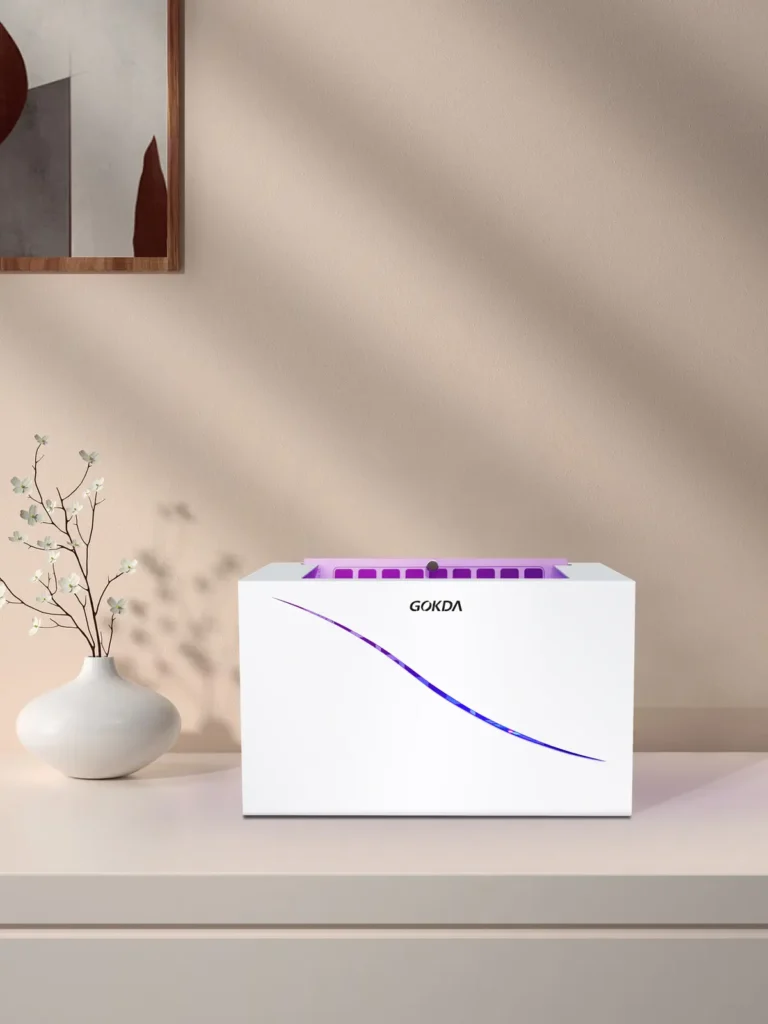 GOKDA Nest 1 Standard White: Sleek Front Design for Home & Indoor Use Front view of the sleek white GOKDA Nest 1 standard size mosquito trap, ideal for home and indoor use. It is placed on a surface next to a decorative vase against a warm, soft indoor background.