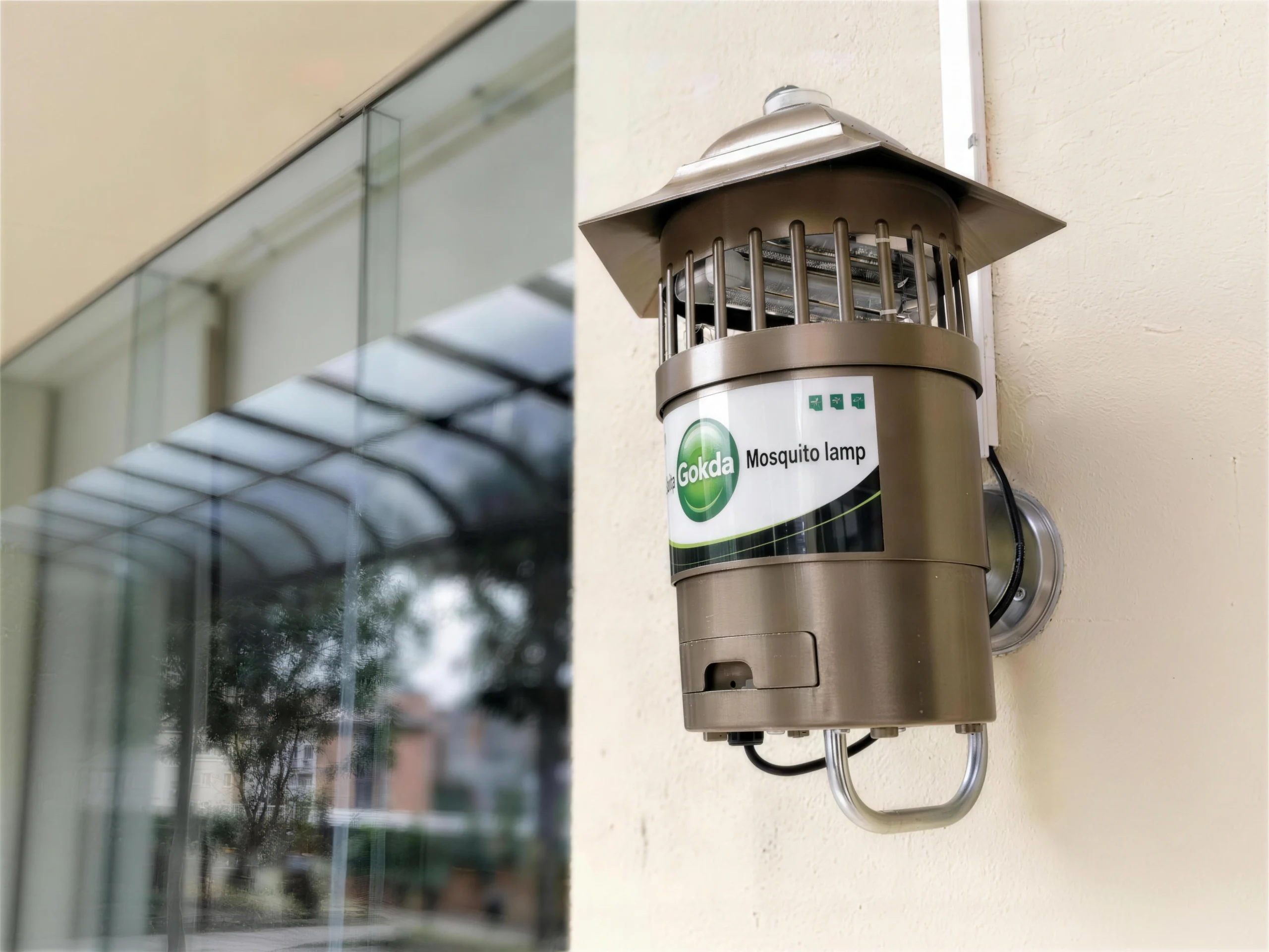 Real-world installation view of the W-B01 Wall-Mounted Mosquito Control Lamp (Bronze/Gold) secured to an exterior wall of a hotel or commercial building.